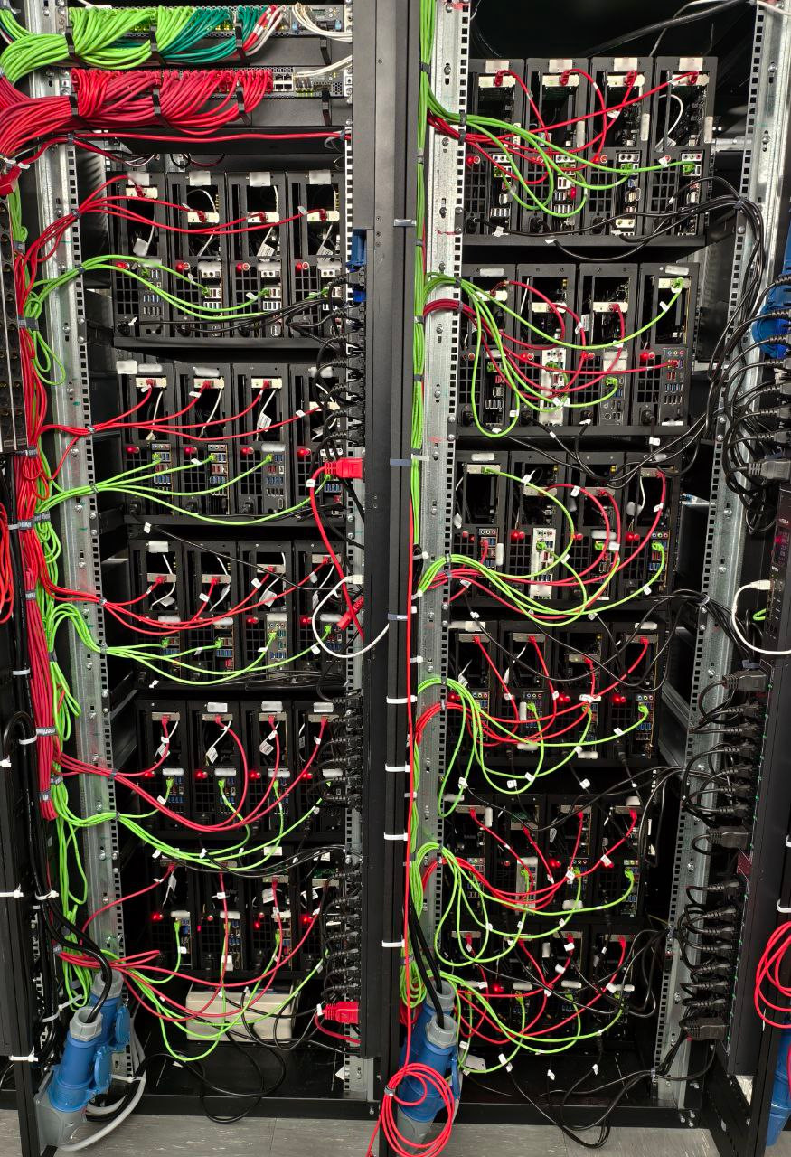 Вид сзади на серверную стойку, заполненную полками с платформами Slim Tower. Показаны задние панели серверов и плотная разводка кабелей питания и сетевых подключений со стороны горячего коридора.