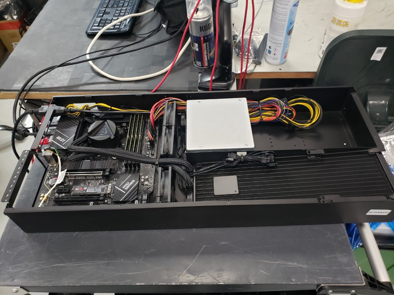 Внутреннее устройство корпуса UltraSlim со снятой крышкой. В очень узком вертикальном шасси плотно скомпонованы материнская плата с водоблоком ЦП и трехсекционный радиатор системы жидкостного охлаждения.