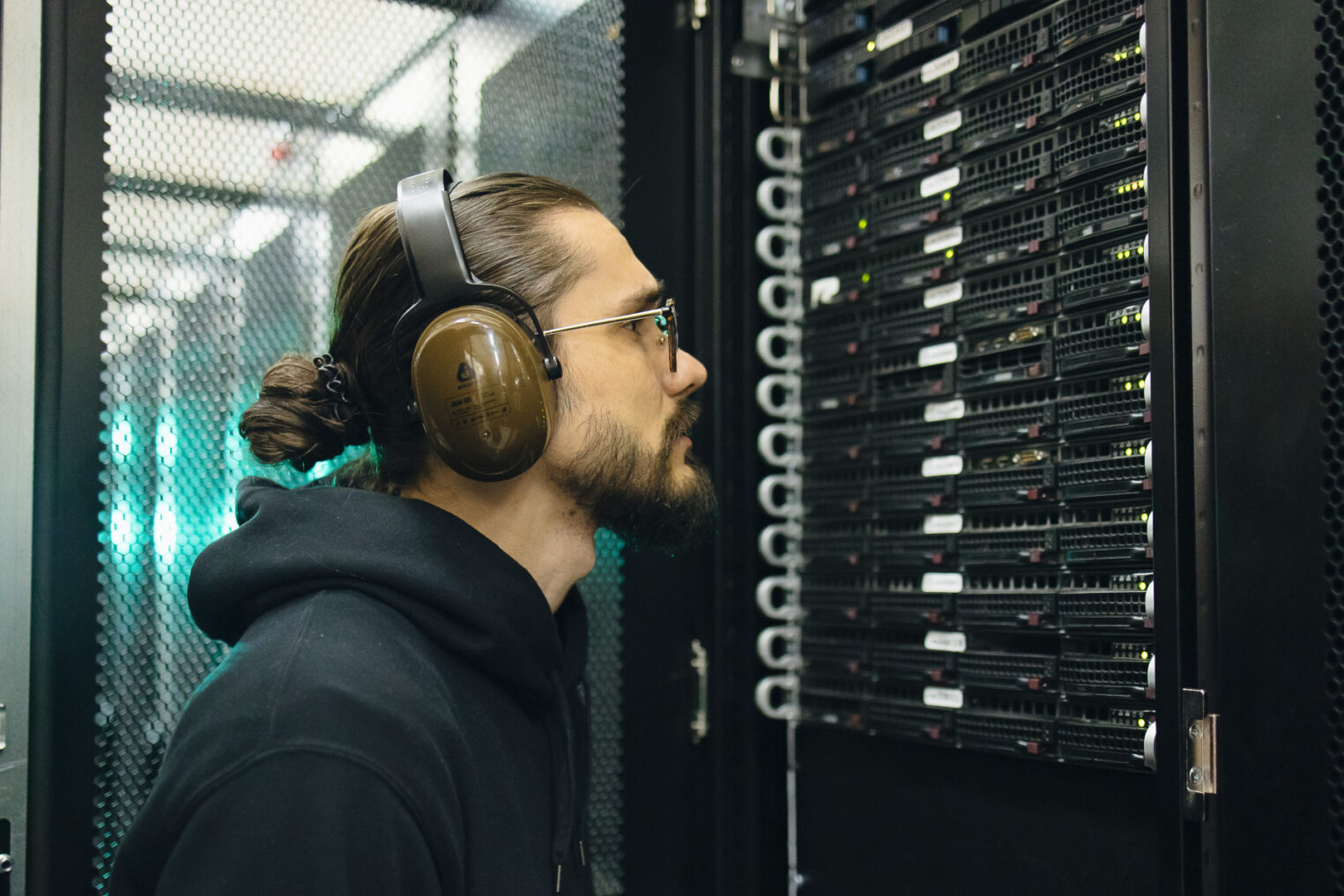 Специалист Selectel внимательно смотрит на маркировку оборудования в серверной стойке.