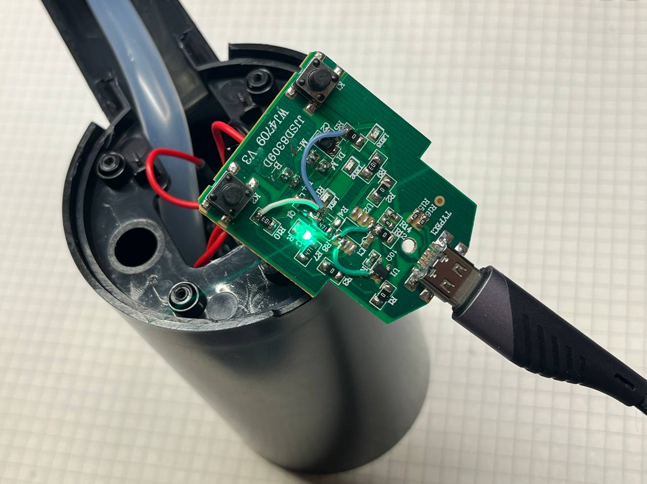 Плата извлечена из корпуса, но подключена; горит зеленый индикатор зарядки.