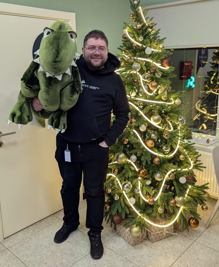 Виталий с Тирексом на фоне елки.
