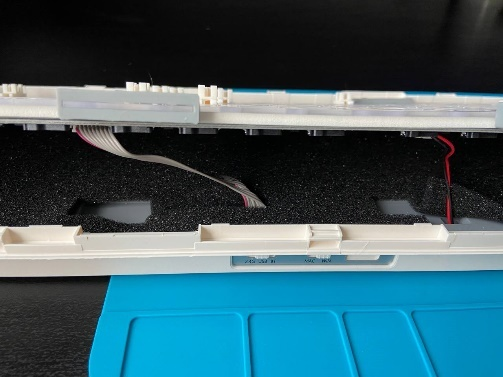 Приоткрытый корпус клавиатуры: видны провода подключения аккумулятора и шлейф передачи данных.