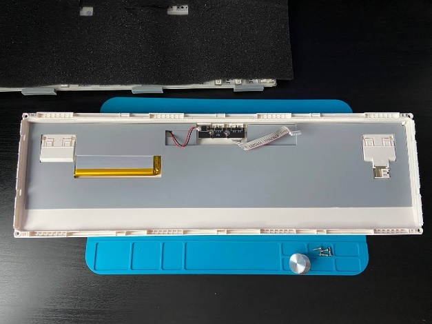 Силиконовый резиноподобный слой серого цвета на дне разобранного корпуса клавиатуры.