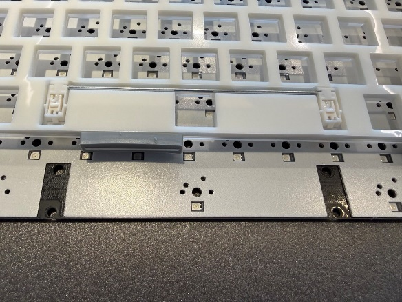 Белый лист шумопоглощающего поролона, проложенный между пластиной и печатной платой.