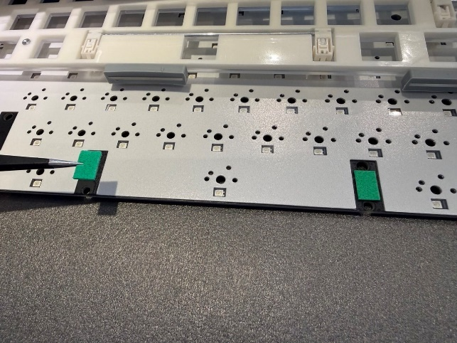 Моддинг печатной платы: наклейка прямоугольников зеленого фоамирана под посадочные места стабилизаторов (band-aid mod).