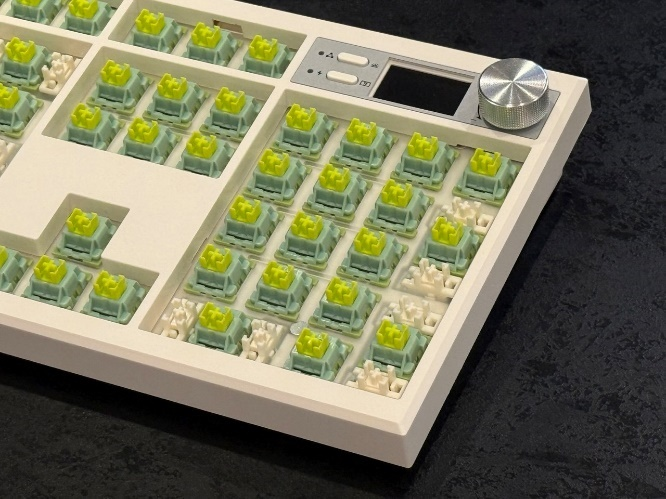 Ближний план: пластина клавиатуры, полностью заполненная установленными зелеными переключателями Outemu Silent Lemon.