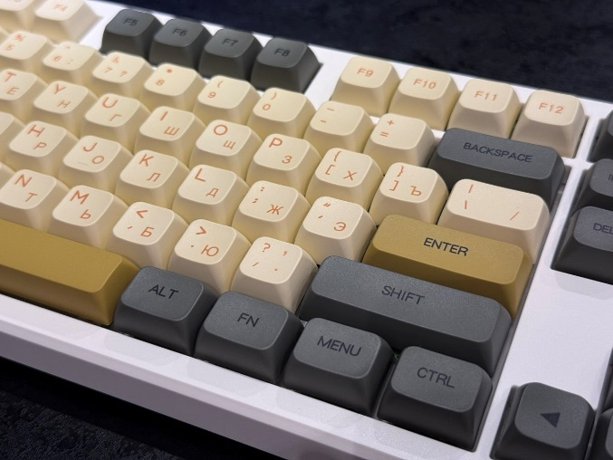 Центральная часть собранной кастомной клавиатуры крупным планом: установлены серо-бежевые колпачки с золотистыми акцентами.