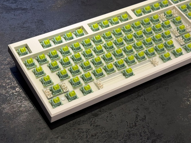 Общий план: пластина клавиатуры, полностью заполненная установленными зелеными переключателями Outemu Silent Lemon.