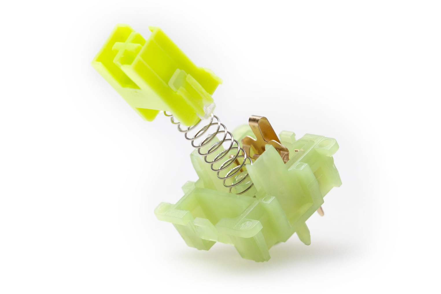 Разобранный переключатель Outemu: виден зеленый корпус, металлические контакты и возвратная пружина.