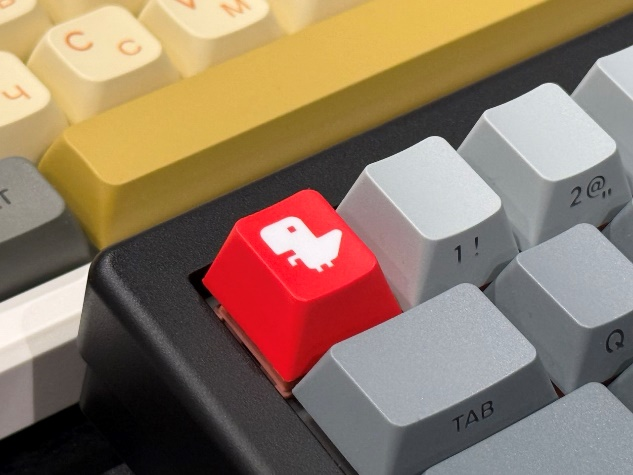 Красная клавиша с динозавриком Тирексом — маскотом компании Selectel.