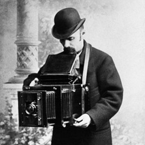 Фотограф настраивает зеркальный фотоаппарат.