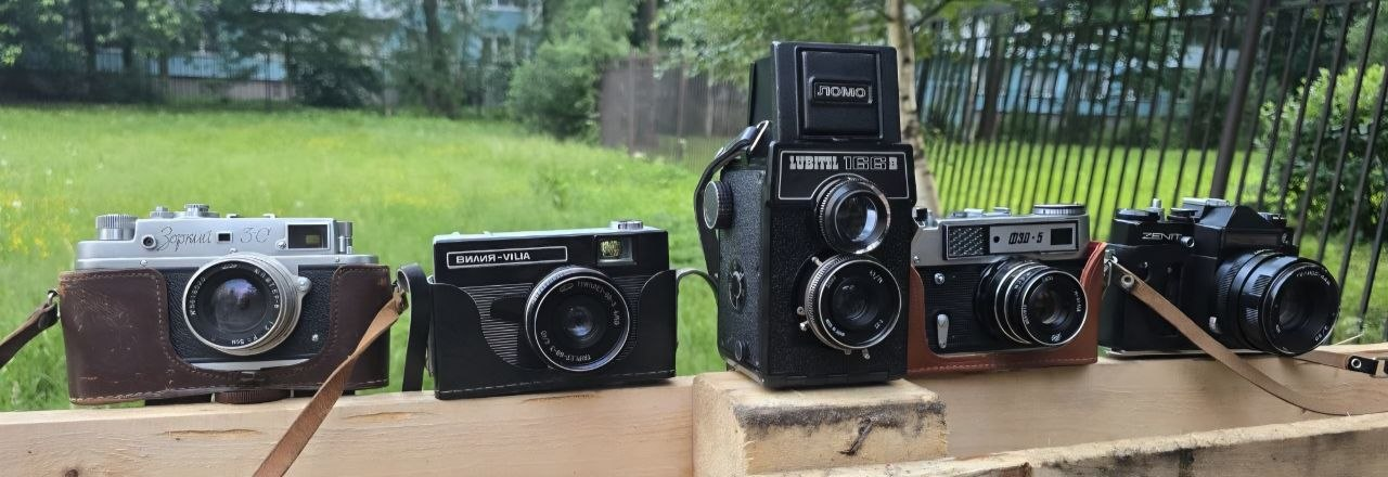Коллекция советских пленочных фотоаппаратов на деревянной поверхности.