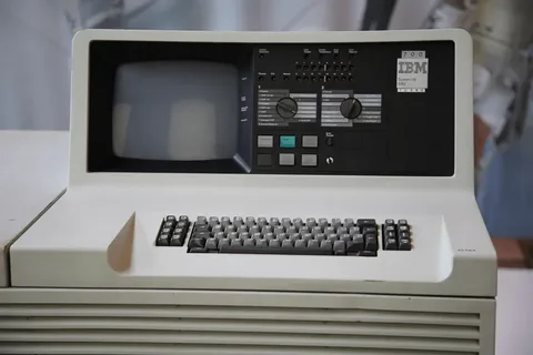 Винтажный компьютерный терминал IBM System/38 с монитором и клавиатурой.
